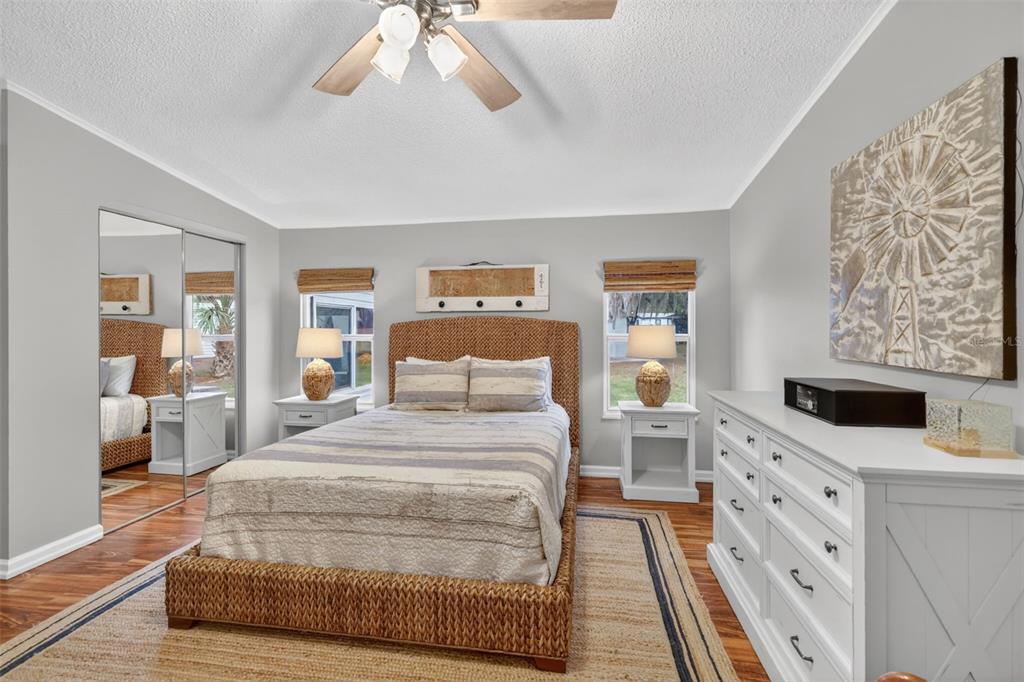 705 Devon Drive Lady Lake, FL 32159 - Photo 13 of 31 a spacious bedroom with a large bed and a chandelier