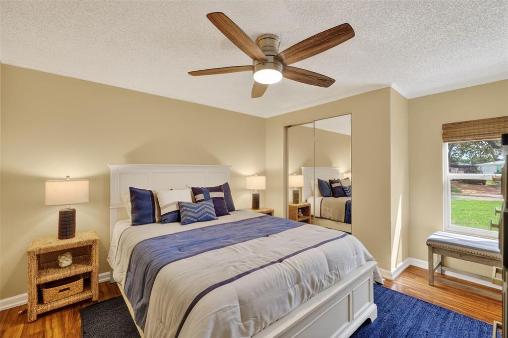 705 Devon Drive Lady Lake, FL 32159 - Photo 19 of 31 a bedroom with a bed and a large mirror