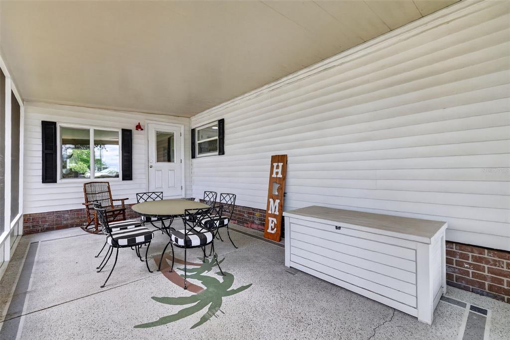 705 Devon Drive Lady Lake, FL 32159 - Photo 23 of 31 a view of a patio with table and chairs with wooden floor and fence