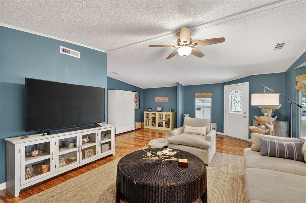 705 Devon Drive Lady Lake, FL 32159 - Photo 4 of 31 a living room with furniture and a flat screen tv