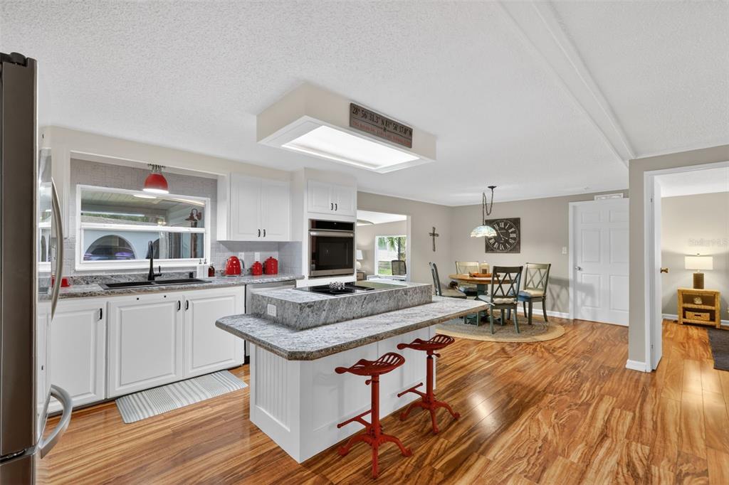705 Devon Drive Lady Lake, FL 32159 - Photo 8 of 31 a open kitchen with stainless steel appliances granite countertop a stove and a wooden floors