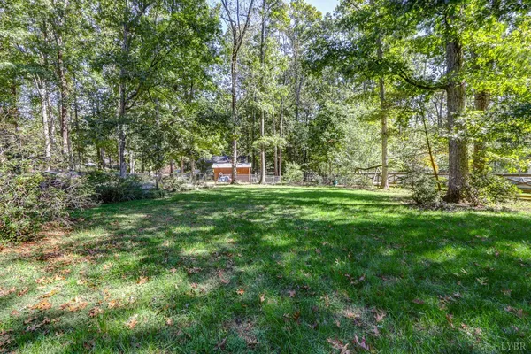 a view of green field with trees in the background