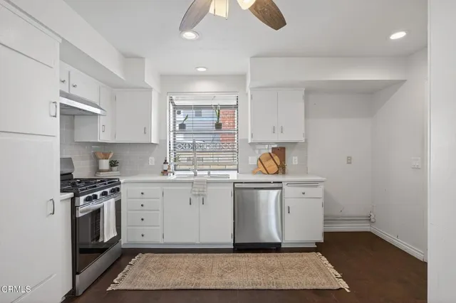 a kitchen with stainless steel appliances granite countertop a stove a sink and a refrigerator