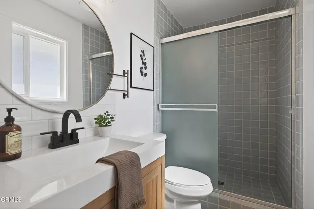 a bathroom with a sink a toilet and shower