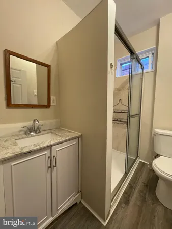 a bathroom with a granite countertop sink toilet and shower