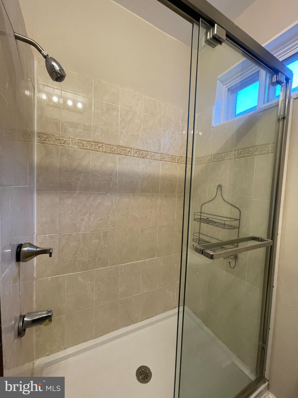 5410 Kingsessing Avenue Philadelphia, PA 19143 - Photo 13 of 17 Sleek glass shower with elegant tile accents.