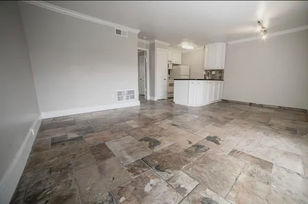 a view of a kitchen with white cabinets and stainless steel appliances