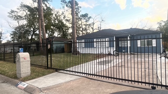 a view of a brick house with a small yard and wooden fence