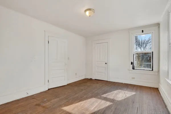 a view of a small space with wooden floor and a window