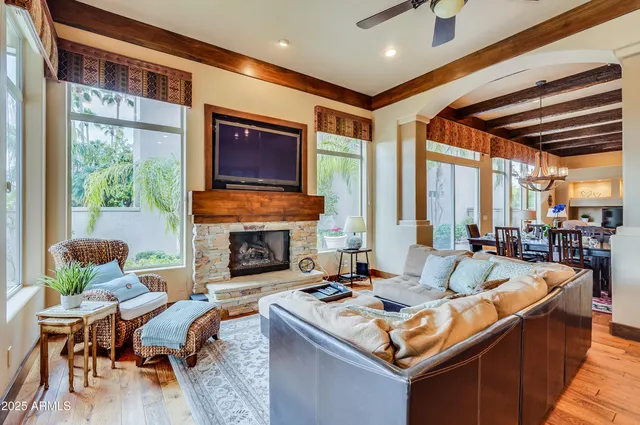 a living room with fireplace furniture and a large window
