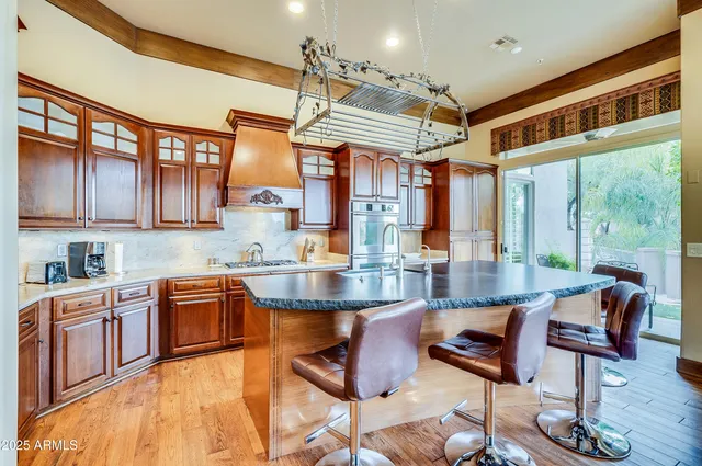a kitchen with stainless steel appliances granite countertop a stove and a view of living room