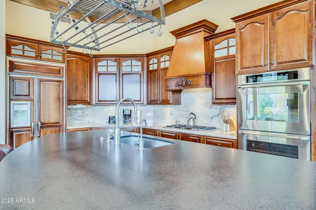 a view of a kitchen with stainless steel appliances granite countertop a lot of counter space and a wooden floors