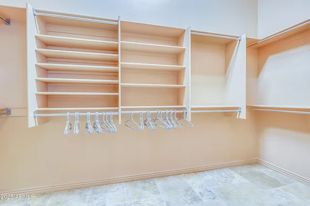 a view of walk in closet with empty racks
