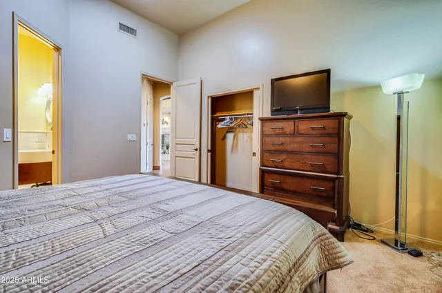 a bedroom with a bed and a flat screen tv