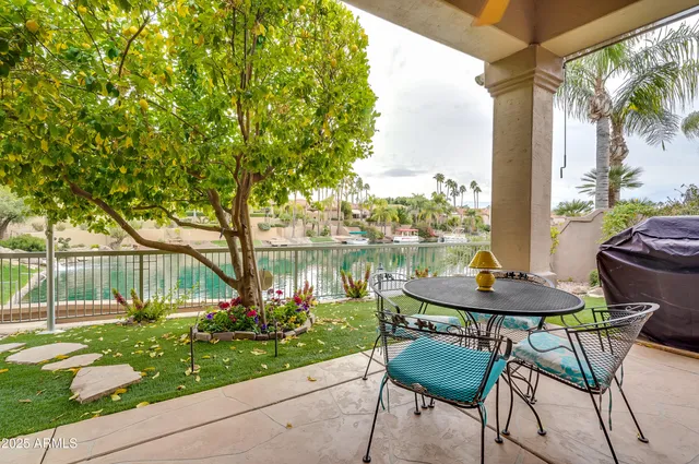 a view of a chair and table in backyard of a house