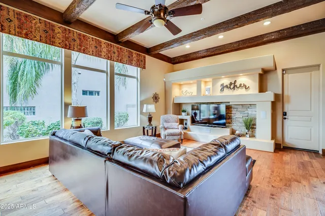 a living room with fireplace furniture and a large window