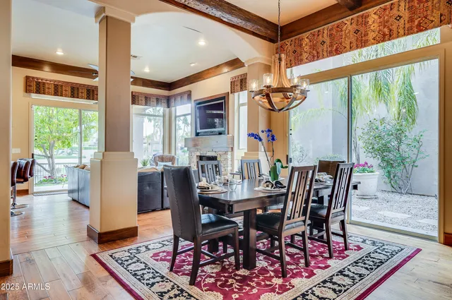 a dining room with furniture a chandelier and wooden floor