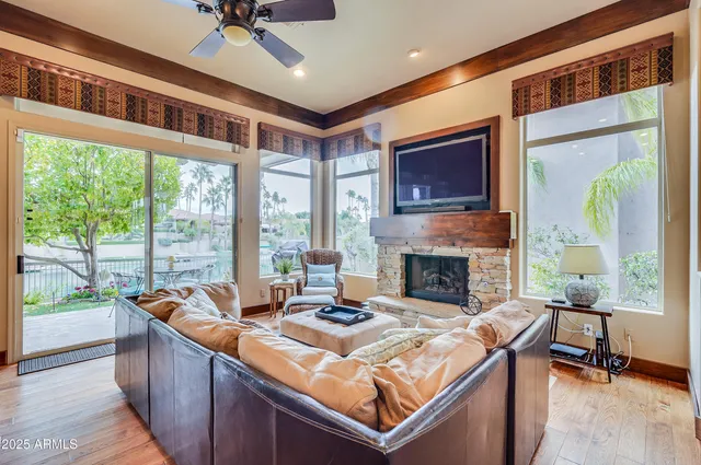 a living room with fireplace furniture and a large window