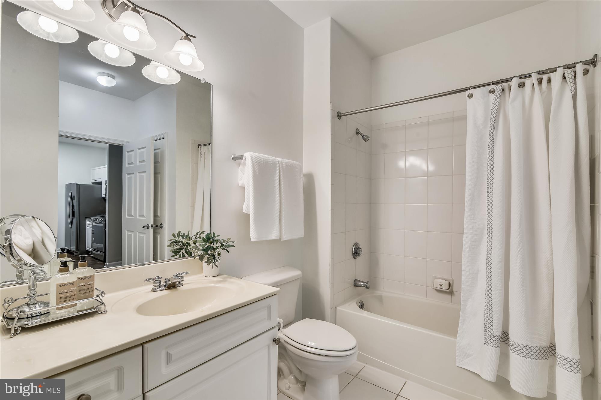 2726 Gallows Road, Unit 113 Vienna, VA 22180 - Photo 14 of 29 a bathroom with a sink a toilet a mirror a vanity and shower