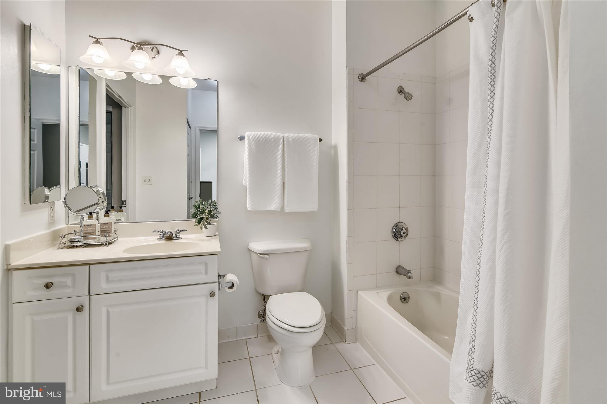 2726 Gallows Road, Unit 113 Vienna, VA 22180 - Photo 15 of 29 a bathroom with a sink a toilet a mirror a bathtub and shower
