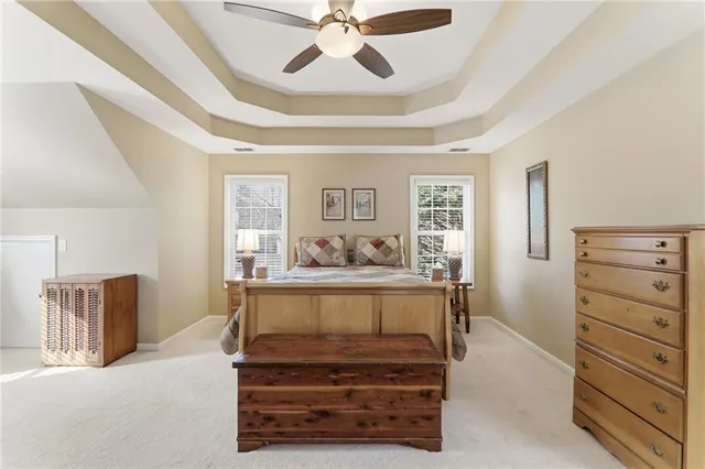 a spacious bedroom with a bed a couch and dresser