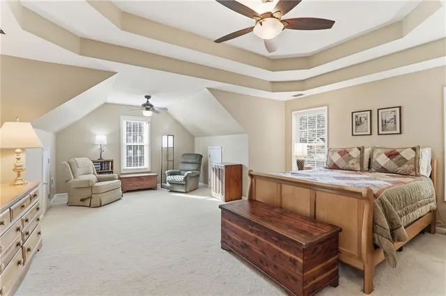 a spacious bedroom with a bed and a chandelier