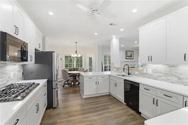 a large kitchen with kitchen island a sink a stove a center island and stainless steel appliances