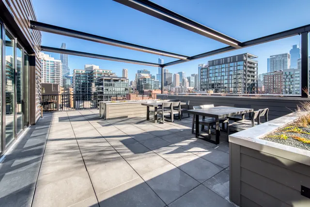 a view of a patio with dining table and chairs with a barbeque