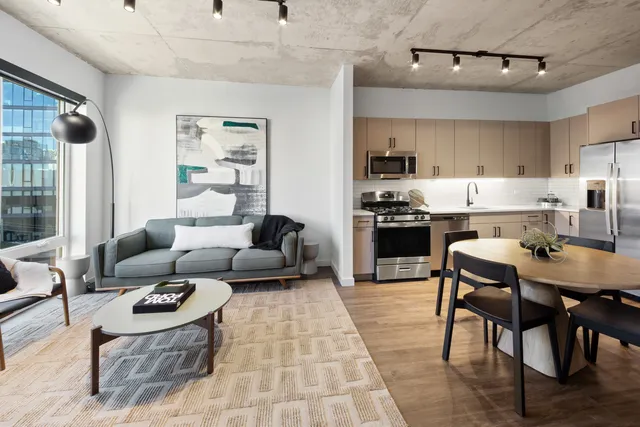 a living room with furniture and a dining table with kitchen view