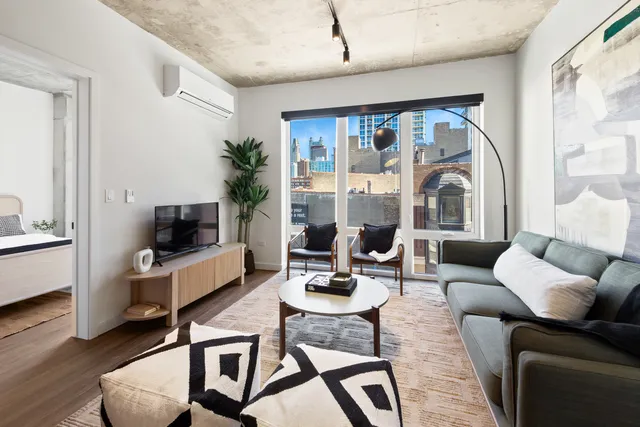 a living room with furniture a flat screen tv and a large window