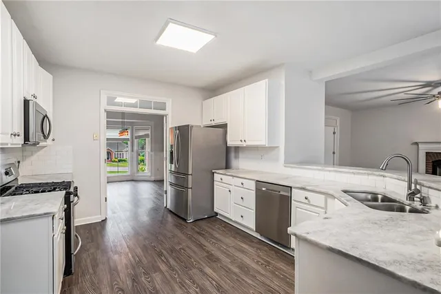 a kitchen with a refrigerator a sink dishwasher and a stove with wooden floor