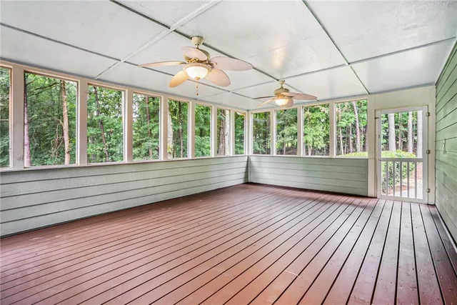 en empty room with wooden floor and windows