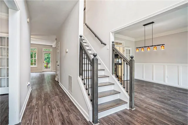 a view of a hallway with wooden floor and staircase