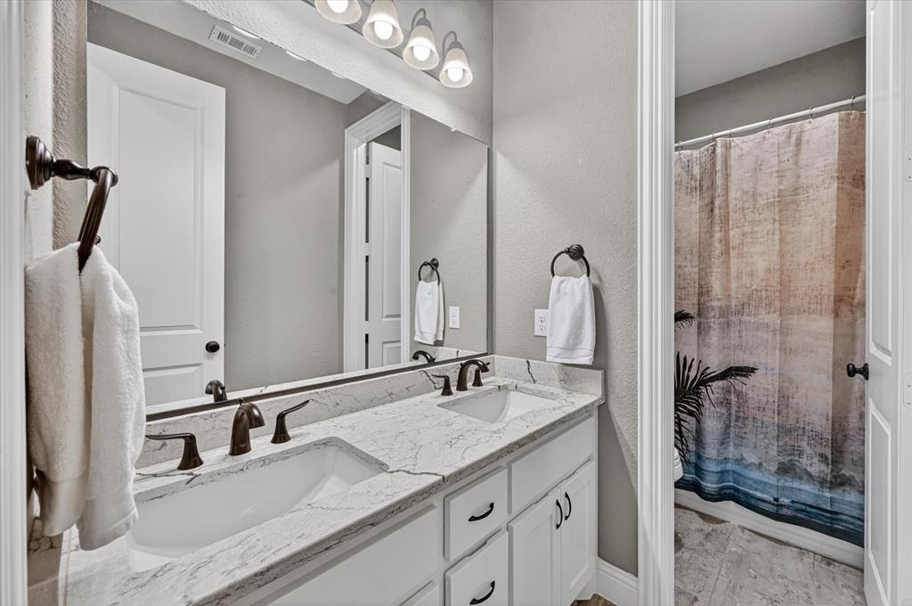 6656 Roughleaf Ridge Road Flower Mound, TX 76226 - Photo 23 of 40 a bathroom with a sink vanity granite and a mirror