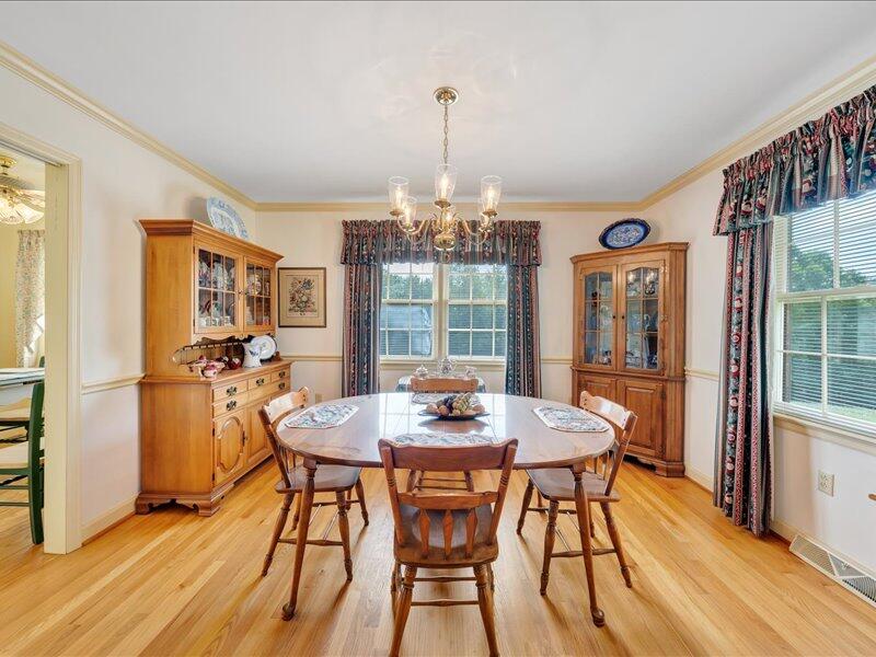 1091 Cool Rock Road Vinton, VA 24179 - Photo 16 of 44 a dining room with furniture window wooden floor and a chandelier