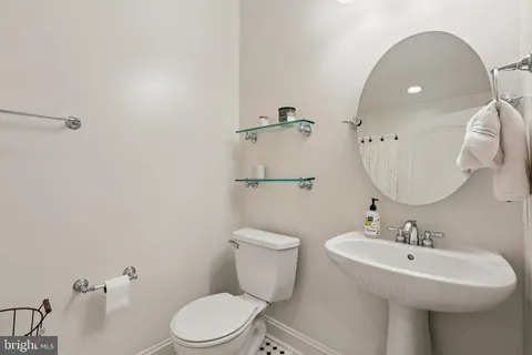 a bathroom with a toilet a sink and mirror