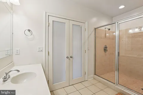 a bathroom with a sink a glass door and shower