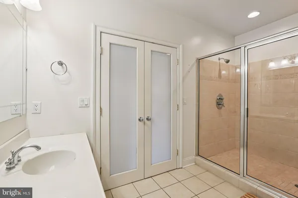 a bathroom with a sink a glass door and shower