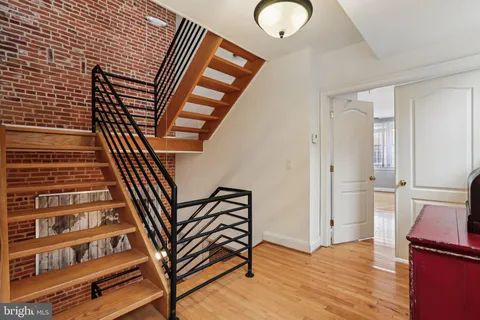 a view of a hallway with wooden floor and staircase