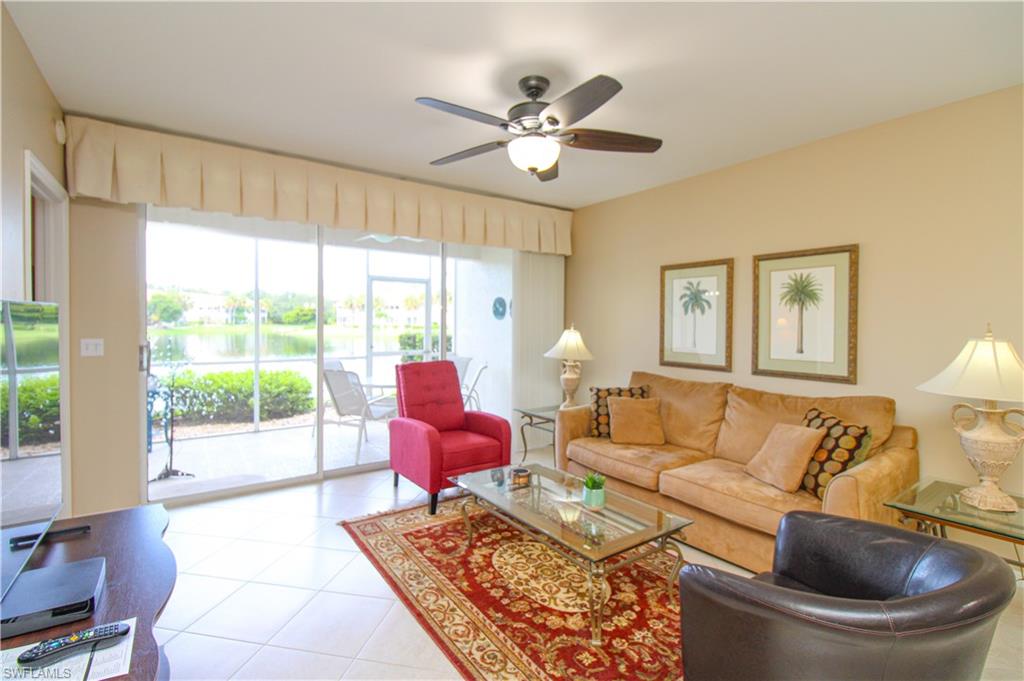 5025 Cedar Springs Drive, Unit 102 Naples, FL 34110 - Photo 17 of 50 Tiled living room featuring ceiling fan and a healthy amount of sunlight