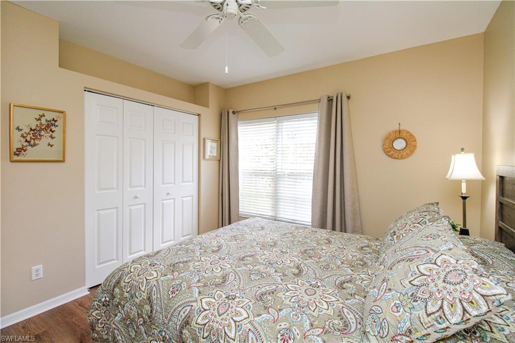 5025 Cedar Springs Drive, Unit 102 Naples, FL 34110 - Photo 35 of 50 Bedroom featuring a closet, ceiling fan, and hardwood / wood-style floors