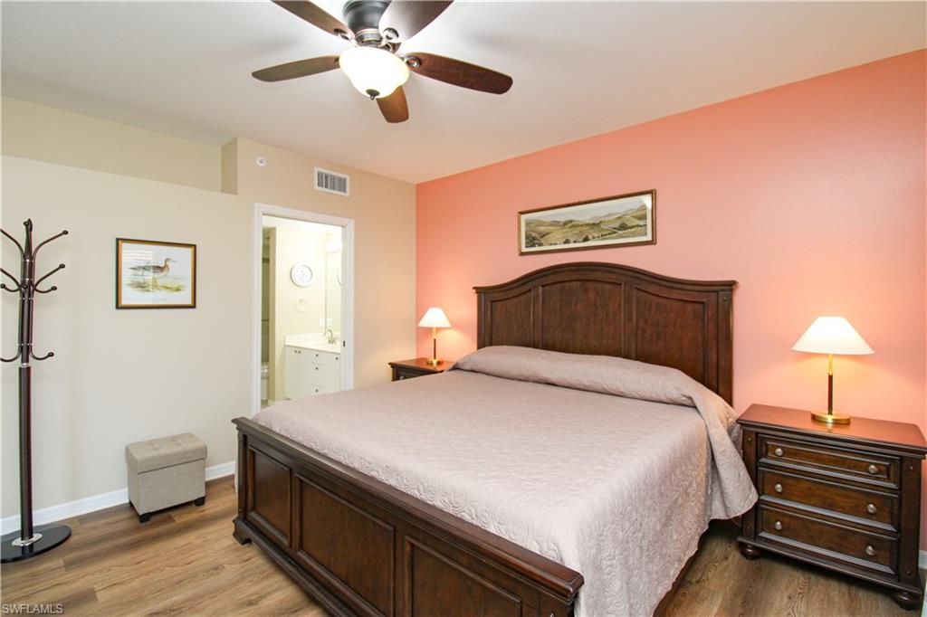 5025 Cedar Springs Drive, Unit 102 Naples, FL 34110 - Photo 37 of 50 Bedroom featuring wood-type flooring, ensuite bathroom, and ceiling fan