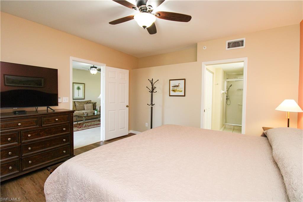 5025 Cedar Springs Drive, Unit 102 Naples, FL 34110 - Photo 38 of 50 Bedroom featuring ensuite bath, dark hardwood / wood-style floors, and ceiling fan