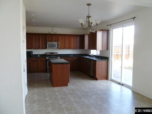9265 Hummer Drive Reno, NV 89521 - Photo 6 of 13 a kitchen with stainless steel appliances granite countertop a stove a sink a refrigerator and a microwave