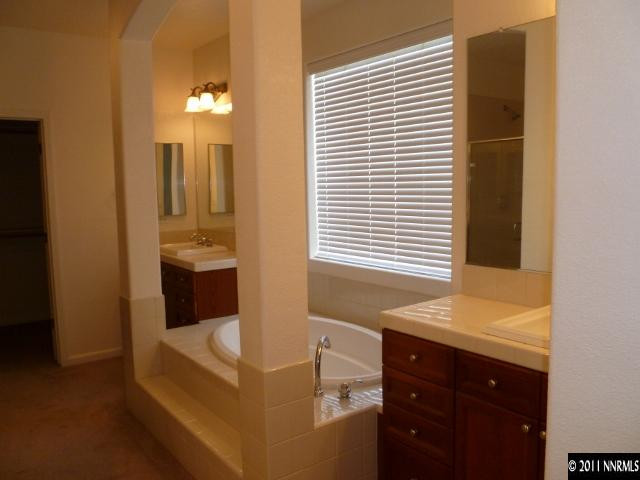 9265 Hummer Drive Reno, NV 89521 - Photo 9 of 13 a bathroom with a tub sink and mirror