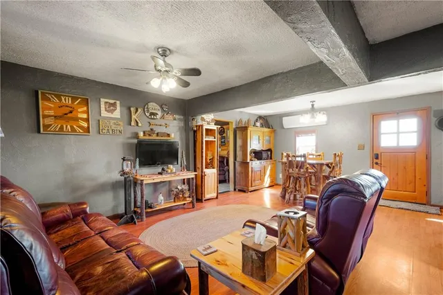 a living room with furniture a flat screen tv and kitchen view
