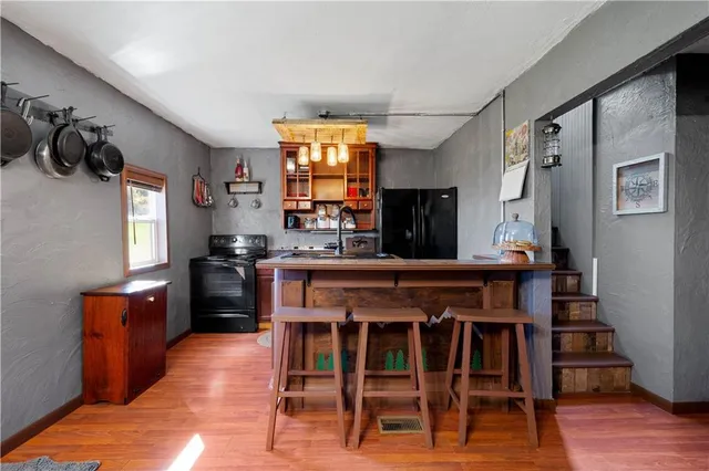 a open kitchen with stainless steel appliances kitchen island granite countertop a table and chairs in it