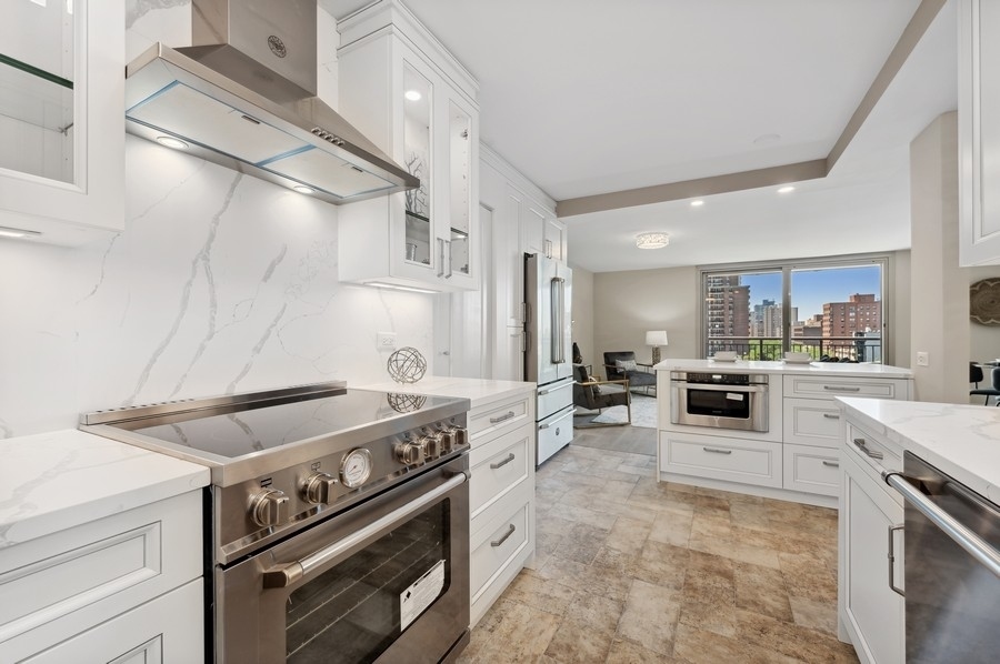 6007 North Sheridan Road, Unit 7J Chicago, IL 60660 - Photo 11 of 25 a kitchen with a stove and white cabinets