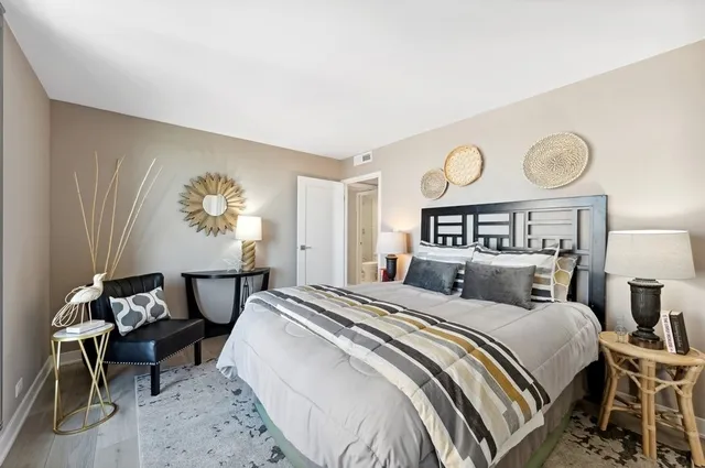 a bedroom with a bed and painting on the wall