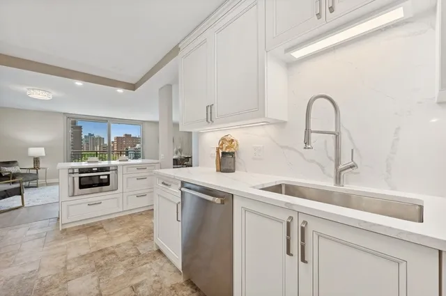 a kitchen with white cabinets and white appliances